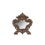 A 19TH CENTURY ITALIAN CARVED GILT WOOD TABLE MIRROR of shell form decorated with acanthus leaves on