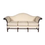 A GEORGE III MAHOGANY FRAMED FOUR SEAT CAMEL BACK SOFA, upholstered in striped cream fabric, the