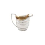 A GEORGE III OVAL CREAM JUG, London 1800, mark of W.A, with gilded interior, the rim, handle and