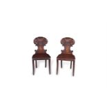 A PAIR OF 19TH CENTURY MAHOGANY HALL CHAIRS, with carved scallop shell backs on 'C' scroll supports,