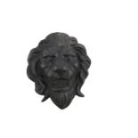 A VICTORIAN CAST IRON LION MASK, mid-19th Century, applied to a white painted timber panel. The