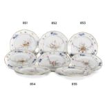 Pareja de platos de porcelana esmaltada con decoración de estilo Luis XVI de triunfos cintas y