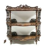 A Victorian burr walnut three-tier whatnot of serpentine outline, with turned supports & finials and