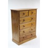 A pine upright chest fitted two short & four long graduated drawers with turned knob handles & on