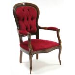A reproduction beech frame elbow chair with buttoned back & padded seat upholstered crimson