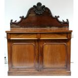 A Victorian mahogany chiffonier with carved and shaped stage back fitted two frieze drawers above