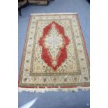 A Persian pattern small carpet of crimson & ivory ground, with multi-coloured geometrical design