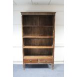 A continental-style tall hardwood bookcase with carved frieze, fitted three open shelves above two