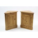 A pair of pine dwarf standing corner cupboard, each fitted shelf enclosed by panel door, & on plinth