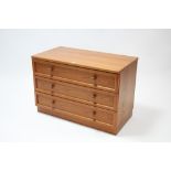 A teak-finish dwarf chest fitted three long drawers, & on plinth base, 34" wide x 23" high.