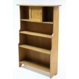 A small oak standing four-tier open bookcase with small centre cupboard to the upper tier & with