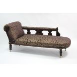 A Victorian carved walnut frame chaise longue, the sprung seat, scroll end & padded rail upholstered