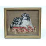 An early Victorian wool & silk needlework picture of a King Charles Spaniel recumbent on a
