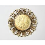 An Austrian gold (585) circular brooch/pendant with open scroll border, the centre set Austro-