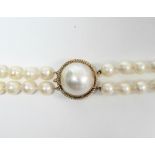 A two-strand necklace of 158 uniform cultured pearls of approx. 7mm diam., the yellow metal clasp