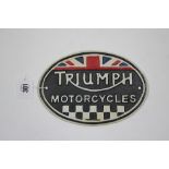 A reproduction painted cast-iron oval sign “TRIUMPH MOTORCYLES”, 5¾” x 8½”.