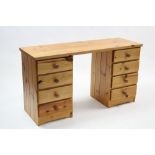 A pine kneehole desk fitted four long drawers to each pedestal, 53¾” wide.