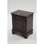 A reproduction mahogany small chest fitted four long drawers with brass ring handles & on bracket