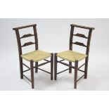 A pair of beech rail-back occasional chairs with woven string seats & on round tapered legs with