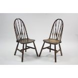 A pair of spindle-back kitchen chairs with shaped hard seats & on turned tapered legs with spindle