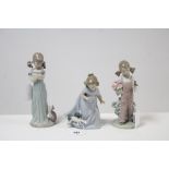 Three Lladro girl figures.