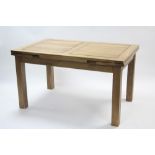 A light oak draw-leaf dining table on square legs, 35¼” x 86½” (open).