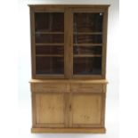 A VICTORIAN PITCH PINE TALL BOOKCASE, the upper part fitted two shelves enclosed by pair of glazed