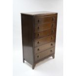 A mid-20th century oak upright chest fitted six long graduated drawers with stylised cast-metal