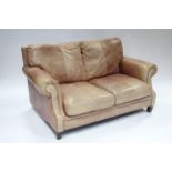 A tan leather three-piece lounge suite comprising a three-seater settee, 79” long, a two-seater