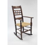 A late 19th century ash & oak rocking chair with woven string seat, & on turned legs with turned