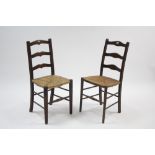 Two beech ladder-back occasional chairs with woven rush seats, & on round tapered legs with