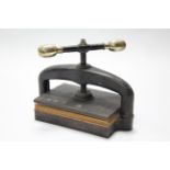 A late Victorian cast iron book press with central worm screw; 19" wide.