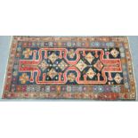 A Persian rug of deep blue ground with bold rust-red geometric pattern forming two rectangular