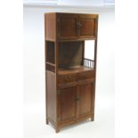 A Chinese hardwood tall cabinet with small cupboard enclosed pair panel doors above a central