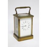 A large brass carriage clock the white enamel dial with black roman hours & Arabic five-minute