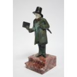 A late 19th/early 20th century cold-painted bronze standing figure of a man with carved ivory
