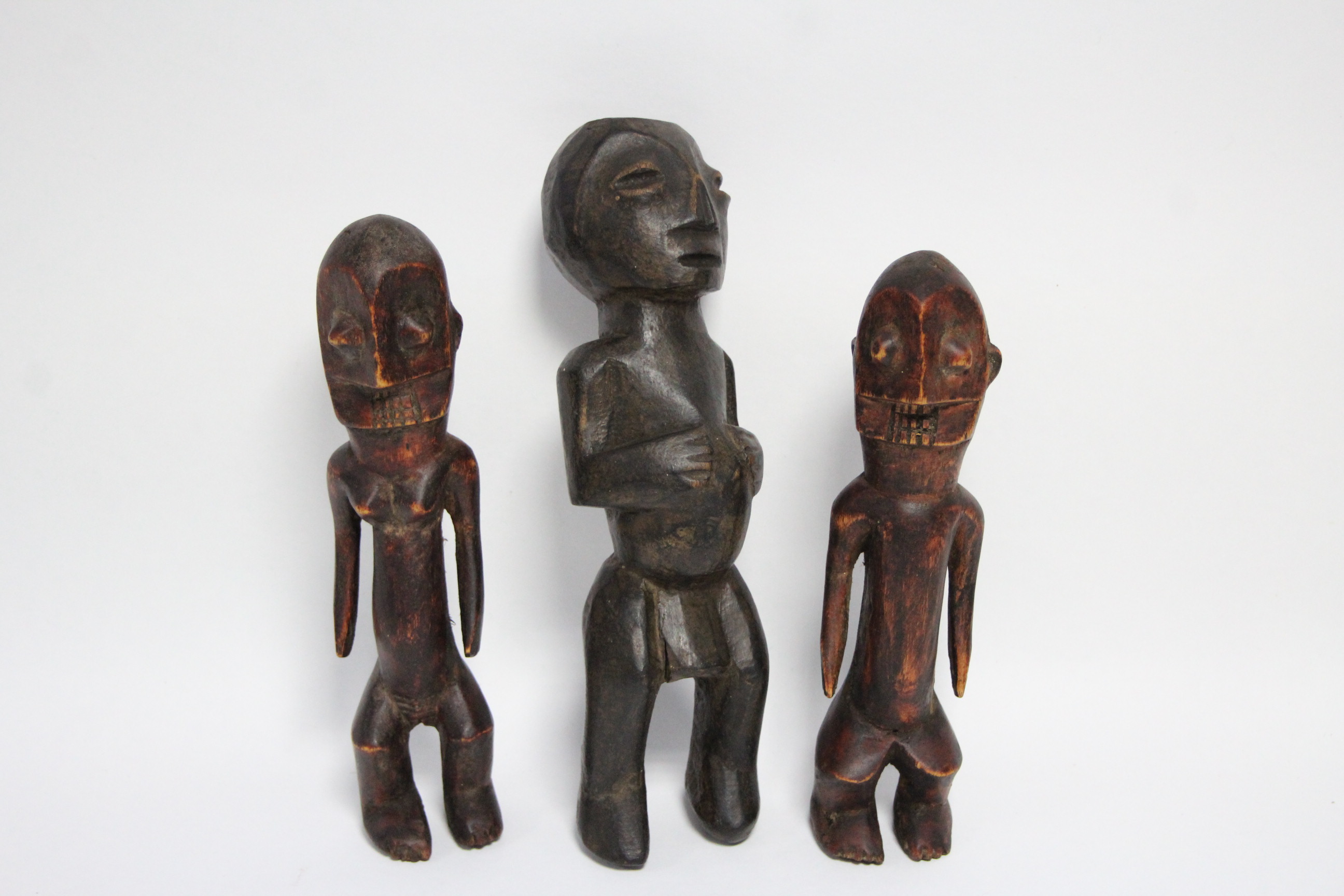 A pair of central African carved wood male & female figures, 9½" & 10" high; & a similar figure,