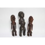A pair of central African carved wood male & female figures, 9½" & 10" high; & a similar figure,