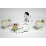 A late 19th century continental porcelain inkstand modelled as a seated Pierrot holding a dish