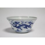 A Chinese blue & white porcelain bowl of ogee form, painted with dragons amongst clouds to the