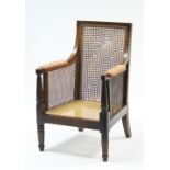 A George IV mahogany bergére with square caned back, padded arms, deep cushioned seat, & on turned