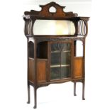 AN EDWARDIAN ART NOUVEAU MAHOGANY DISPLAY CABINET with shaped bevelled mirror to the raised back