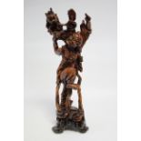A Chinese carved hardwood standing figure of an immortal with mythical beast on his back; 19"