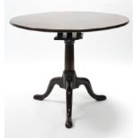 An 18th century mahogany tripod table, the circular tilt-top with birdcage support on turned "gun-