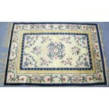 A Chinese silk rug of ivory ground, figured in dark blue, pink, & yellow with scattered flowers &