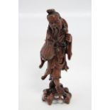 A Chinese carved hardwood figure of a fisherman holding a wicker basket; 14" high.