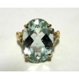 An 18ct gold ring set large oval aquamarine, the split shoulders set small diamonds.