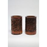 Two Chinese bamboo brush pots carved with figures, animals, birds, & calligraphy; 5" high.