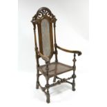A William & Mary style walnut elbow chair with tall carved & pierced cane-panel back, open scroll