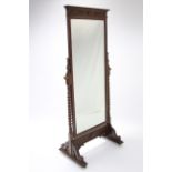 An early 20th century carved oak cheval mirror inset rectangular bevelled plate, & with barley-twist